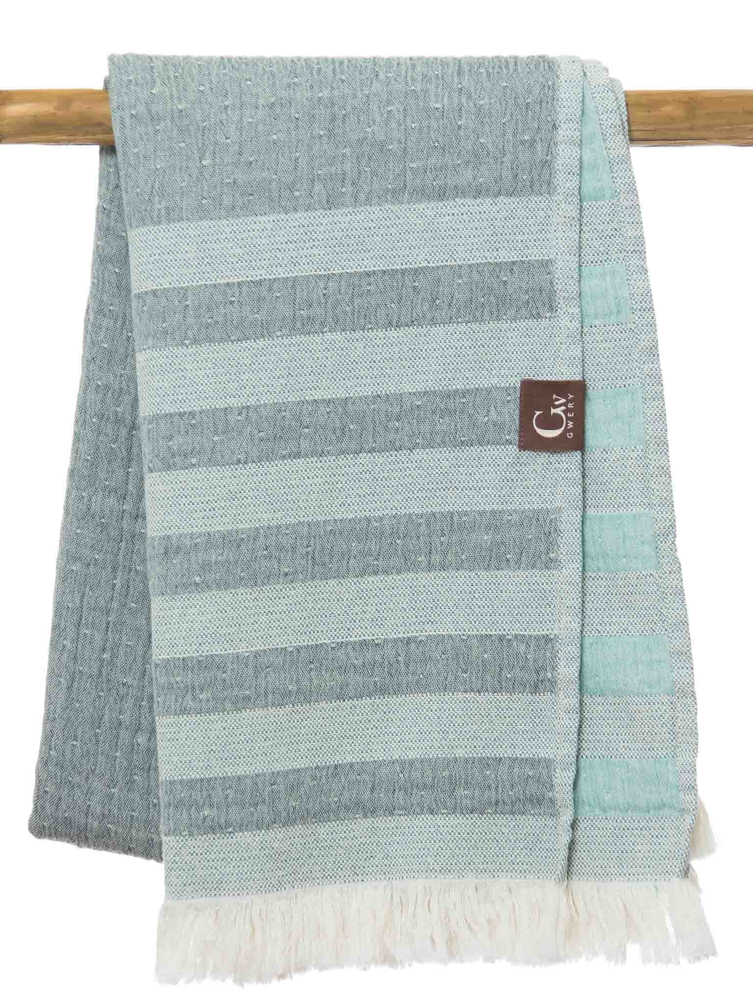 Light and dark green striped beach towel folded