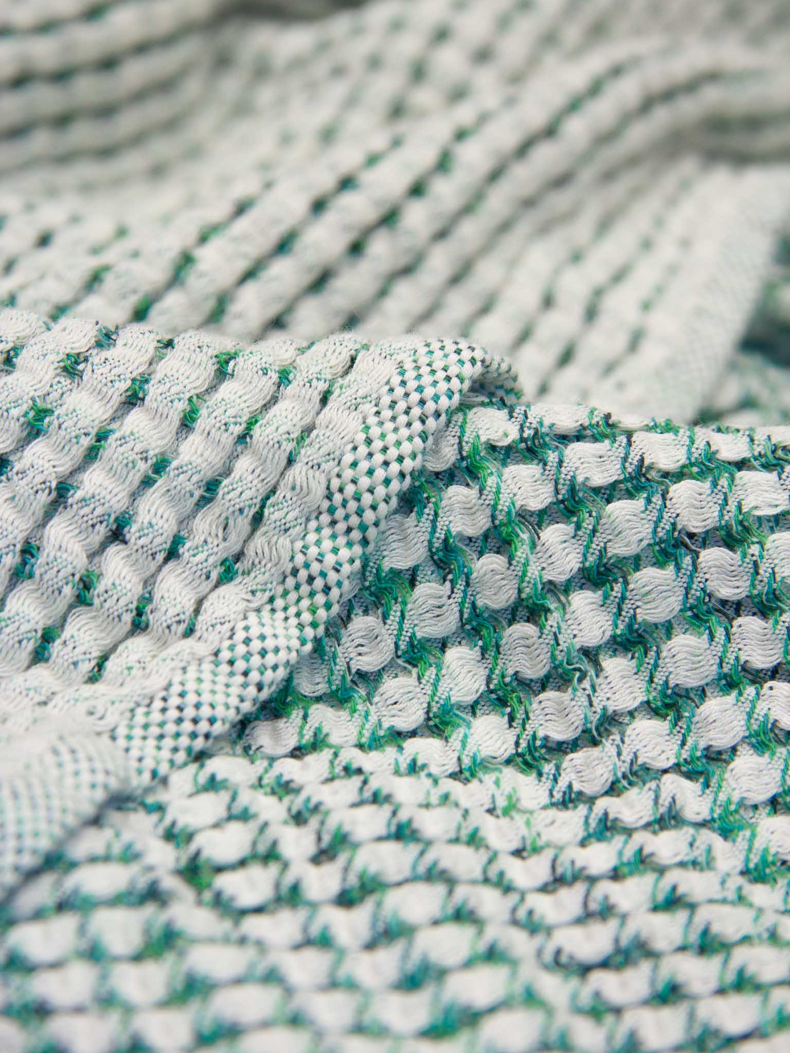 Green patterned double sided, honeycomb beach towel close up
