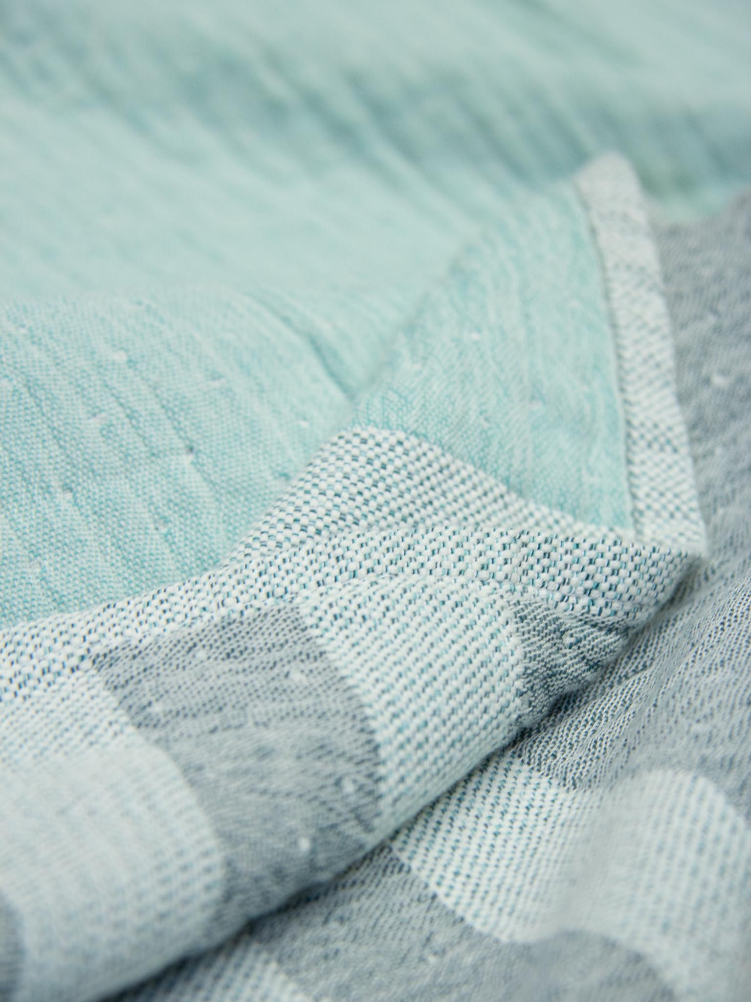 Light and dark green striped beach towel close up