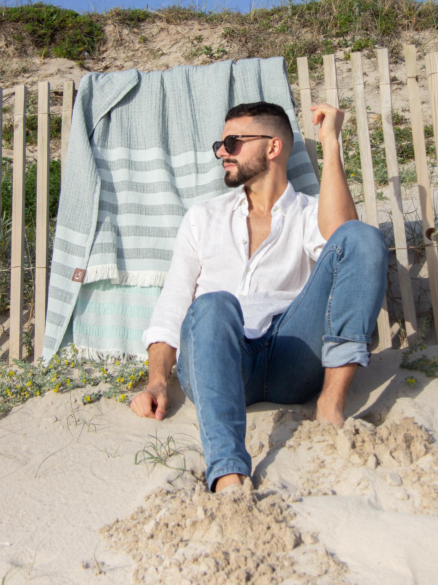 Man with  Light and dark green striped beach towel