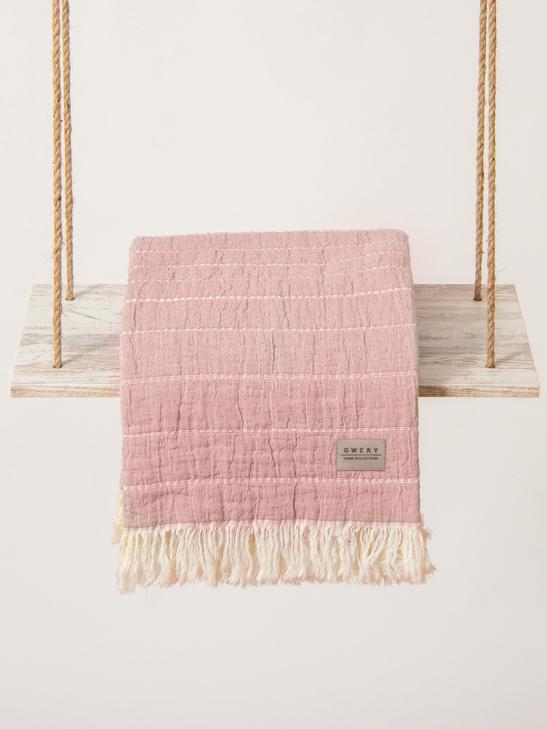 pink blanket with horizontal stripes made of organic cotton