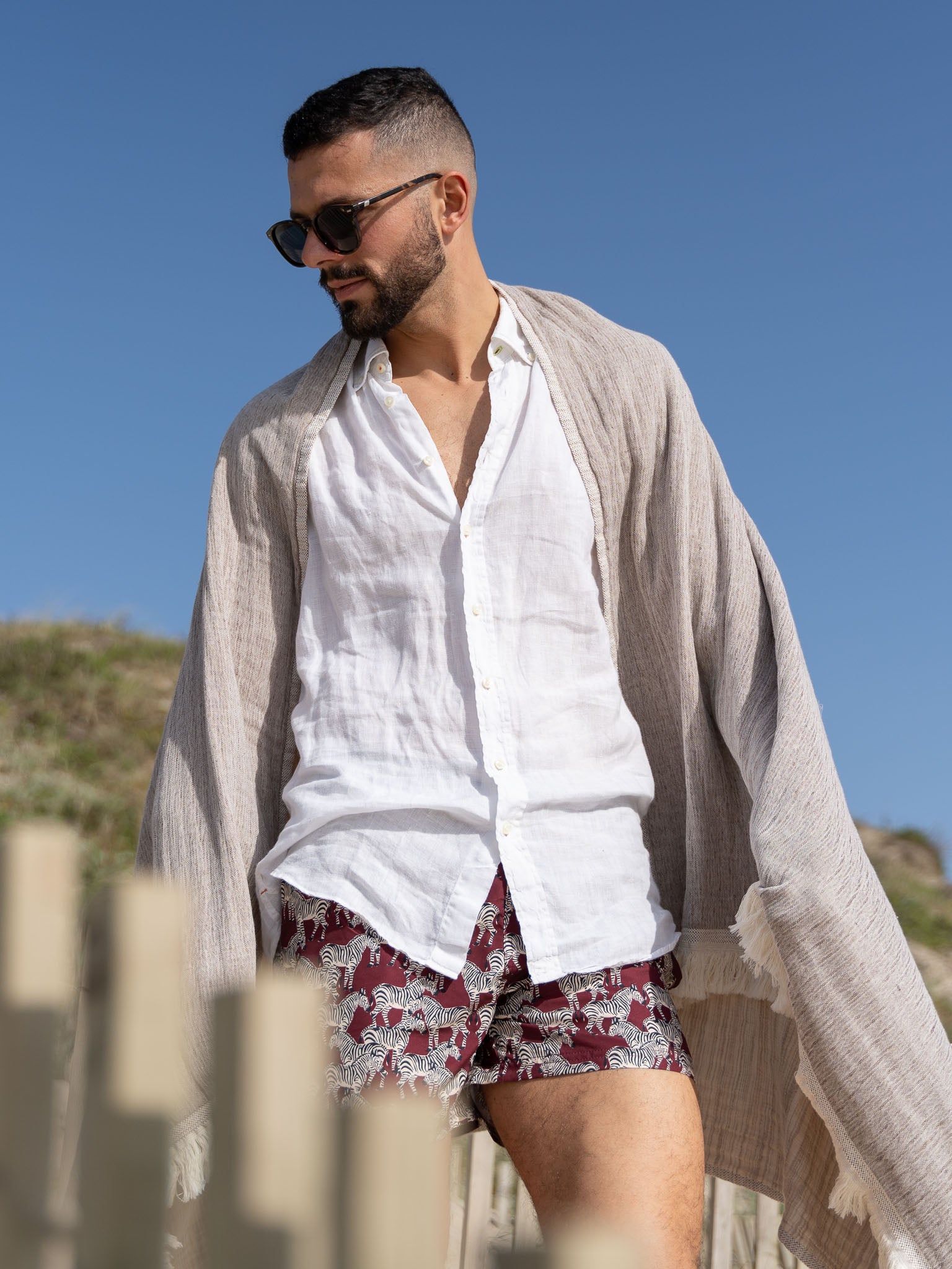Man on the beach with brown patterned, double sided, beach towel